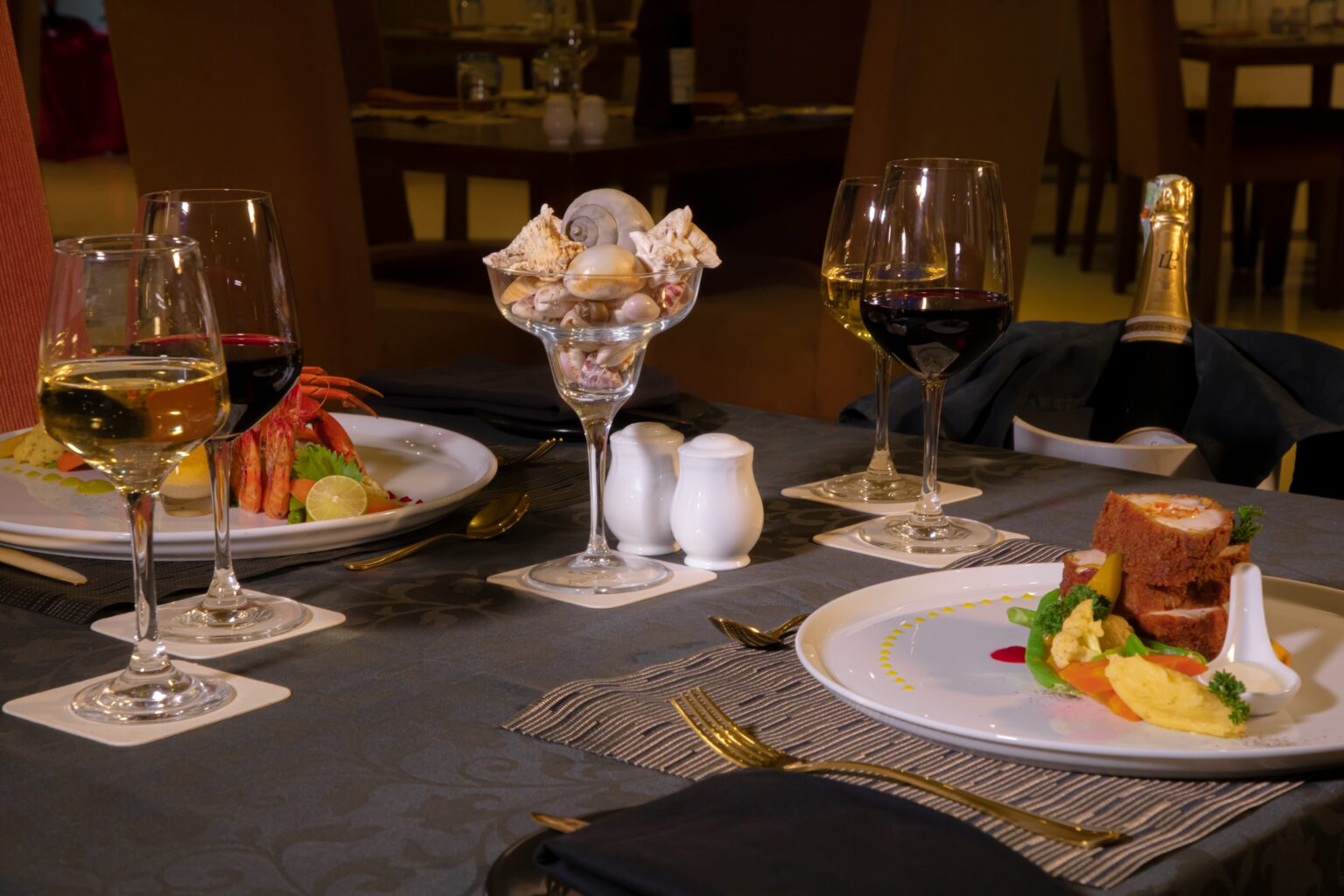 A dinner table laid with wine, seafood and a plated dish in the restaurant